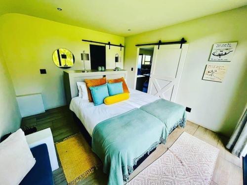 ein Schlafzimmer mit einem großen Bett mit gelber Wand in der Unterkunft Kingsbrook Pods in Clarens