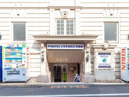 un edificio con dos neveras frente a una tienda en HOTEL LiVEMAX BUDGET Nippori, en Tokio