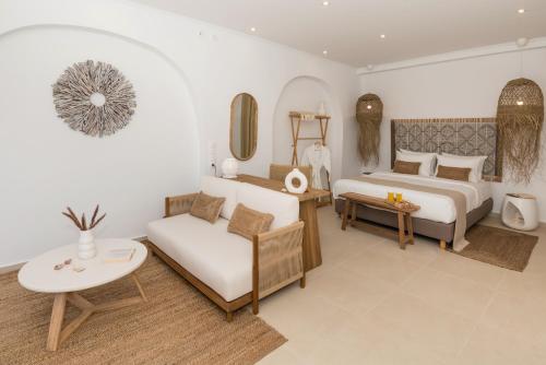 a bedroom with a bed and a couch and a table at Kanelis Milos Sea Suite in Agia Irini Milos