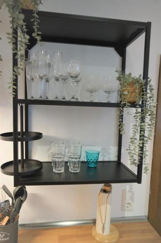 a black shelf with glasses and plants on it at Mill Valley Villa in Koblenz