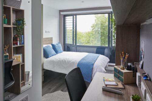 1 dormitorio con cama, ventana y escritorio en Modern Ensuites with Shared Kitchen at Howard Gardens in Cardiff, en Cardiff