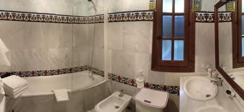 y baño con lavabo, bañera y aseo. en Casa Villa Las Palmeras, en Arriate