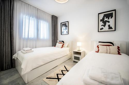 two white beds in a room with a window at Apartamento Alma in Puerto del Carmen