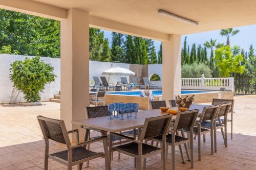 a patio with a table and chairs and a pool at Blue Haven by Fidalsa in Catral