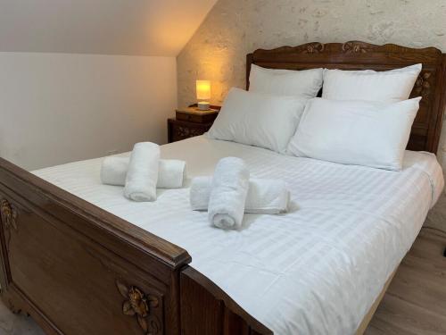 a bed with white sheets and pillows on it at La Maison des anges avec jardin : proche beauval in Billy