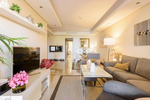 a living room with a couch and a table at Apartamento lujo en primera línea de playa en Bahía de la Plata, Estepona in Estepona