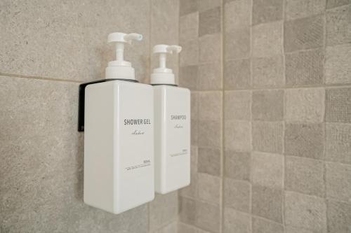 two white bottles are hanging on a wall at Refuge familial urbain en plein coeur de ville in Toulon