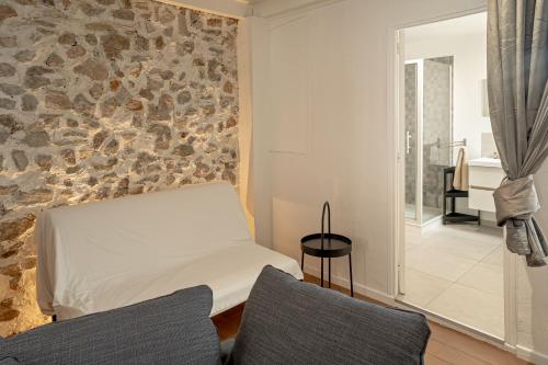 a bedroom with a bed and a stone wall at Refuge familial urbain en plein coeur de ville in Toulon
