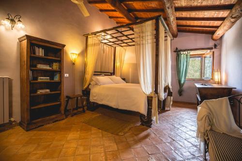 1 dormitorio con cama con dosel en una habitación en Agriturismo locanda settimo cielo, en Lubriano