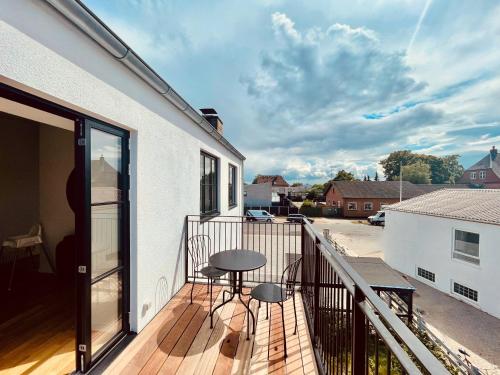a balcony with a table and chairs on a building at Cozy and Bright Apartments with Private Car Park in Copenhagen
