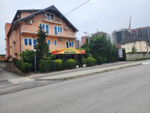 a building on the side of a street with a hotel at Holiday in Ferizaj