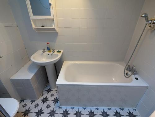 a bathroom with a tub and a sink and a toilet at Hoxton/Shoreditch Rooms in London