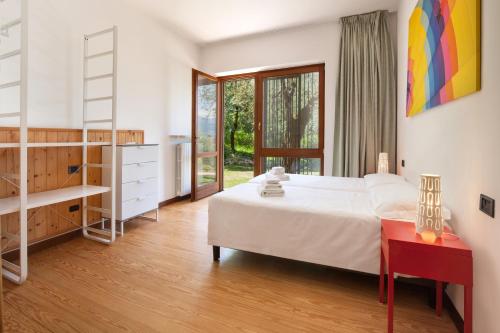 トッリ・デル・ベーナコにあるVilla Carducciのベッドルーム(白い大型ベッド1台、赤いテーブル付)