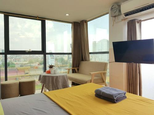a bedroom with a yellow bed and a large window at Libré Homestay in Hanoi