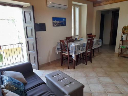 a living room with a couch and a table and chairs at 2 Bedroom, 1 Bath apartment near the sea in Casal Velino