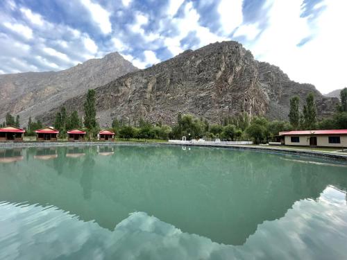 a large pool of water with mountains in the background at Dream Nest Resort in Skardu