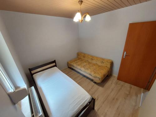 mały pokój z łóżkiem i kanapą w obiekcie Domek letniskowy u Piotera Ślesin Żółwieniec w Ślesinie