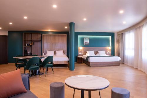 Cette chambre d'hôtel comprend deux lits, une table et des chaises. dans l'établissement Golden Tulip Dieppe Hôtel & Spa, à Saint-Aubin-sur-Scie