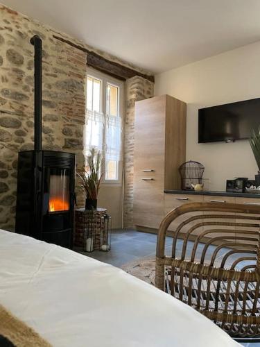 une chambre avec une cheminée et un lit et une chambre avec un lit sidx sidx dans l'établissement Studio cosy ☆☆☆ au coeur de la Vallée de la Rotja, à Sahorre