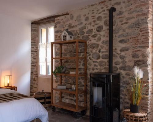 1 dormitorio con cama y pared de piedra en Studio cosy ☆☆☆ au coeur de la Vallée de la Rotja en Sahorre