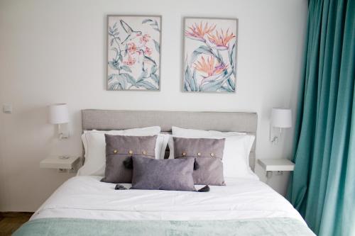 a bedroom with a bed with three pictures on the wall at Ermis Mini Suite # 1 in Chalkida