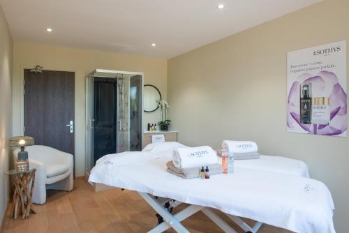 a hospital room with two beds and a mirror at Golden Tulip Dieppe Hôtel & Spa in Saint-Aubin-sur-Scie