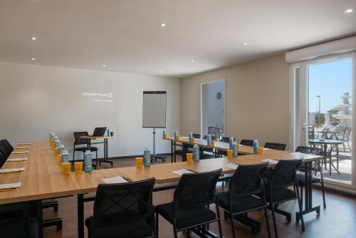 a conference room with a large table and chairs at Golden Tulip Dieppe Hôtel & Spa in Saint-Aubin-sur-Scie