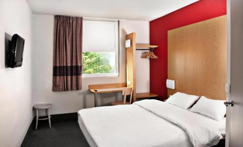 une chambre d'hôtel avec un lit et une fenêtre dans l'établissement B&B HOTEL Wrocław Centrum, à Wrocław