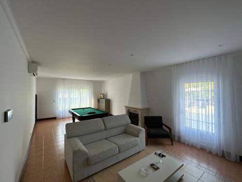 Una sala de estar con un sofá y una mesa de billar. en Quinta da Lu - Azorean Villa, en Ribeira Grande