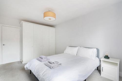 a bedroom with a white bed with towels on it at 1 bed Clapham Junction apartment in London