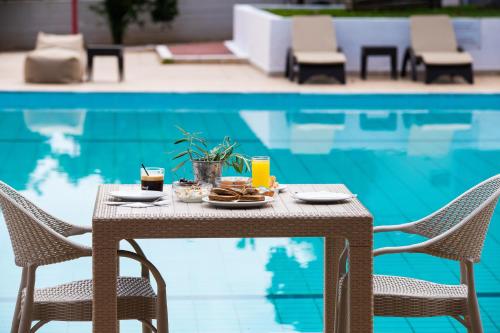 a table with food on it next to a swimming pool at Blue Marine Village in Chalkida