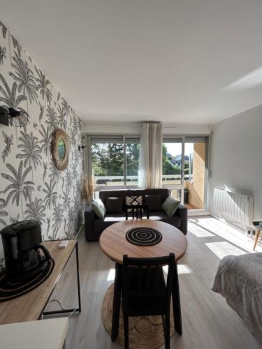 a living room with a table and a couch at Le Lagon, joli studio en bord de mer in Bénodet
