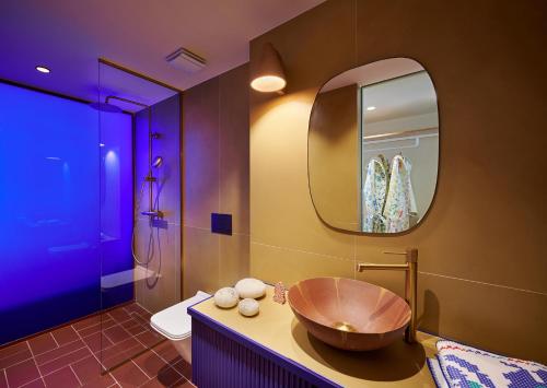 La salle de bains est pourvue d'un lavabo en bois et d'un miroir. dans l'établissement LOOM ATHENS, à Athènes