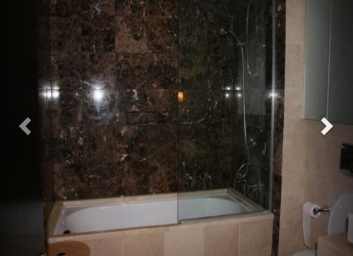 a bathroom with a bath tub with a glass shower at 2 Bed Apartment in Sandyford