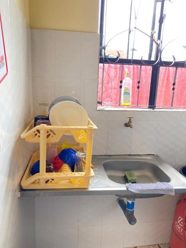 Happy home في أروشا: حمام صغير مع حوض استحمام ومغسلة