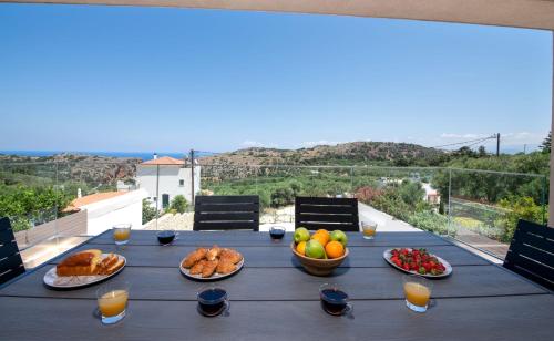 a table with bread and fruit on it with a view at Armour Eclectic Villa in Afráta