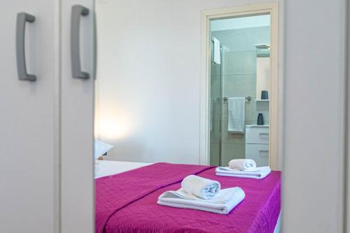 a bedroom with a pink bed with towels on it at Villa Blue Panorama in Vela Luka
