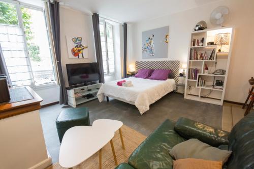 a living room with a bed and a couch at Studio Tarbes Marcadieu in Tarbes