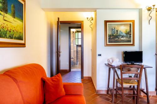 a living room with an orange couch and a table at Casa Vacanza Il Carpignone 7 in Massa Marittima