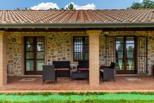 a patio with chairs and a brick house at Casa Vacanza Il Carpignone 7 in Massa Marittima