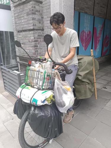 a man sitting on a motor bike with a basket at Riverside International Youth Hostel阅江老院青年旅舍 in Chongqing