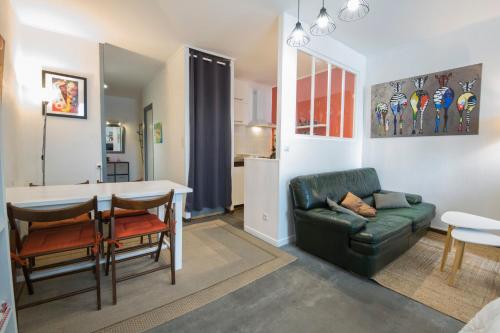 un salon avec un canapé vert et une table dans l'établissement Studio Tarbes Marcadieu, à Tarbes
