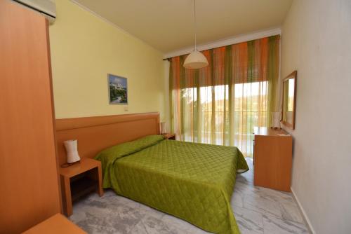 a bedroom with a green bed and a window at Olympic Kosmas Villas in Hanioti