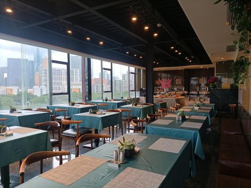 a restaurant with blue tables and chairs and windows at Paco Hotel Shuiyin Road Guangzhou-Canton Fair free shuttle bus in Guangzhou