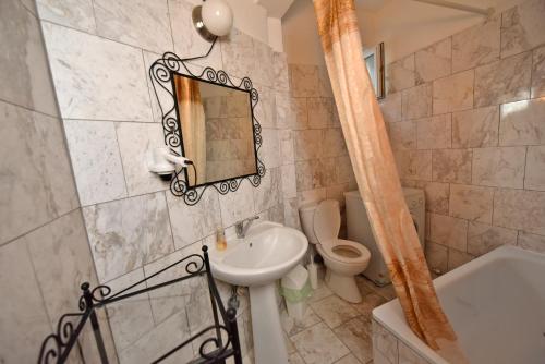 a bathroom with a sink and a toilet and a mirror at Olympic Kosmas Villas in Hanioti