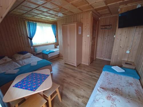 a room with two beds and a flat screen tv at Żegleniówka in Małe Ciche