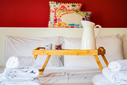 a wooden tray with a vase on top of a bed at Spacious and Modern Apt in the Suburbs of Athens in Athens
