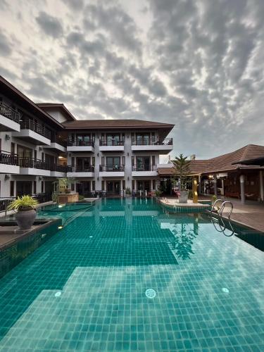 a large swimming pool in front of a building at Suansuk pattaya in Jomtien Beach