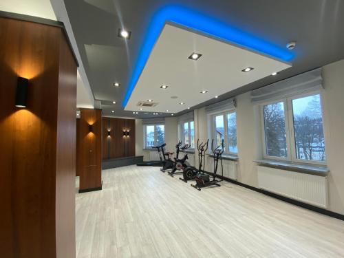 - une salle de sport dotée d'un plafond bleu et de vélos d'exercice dans l'établissement Amelia Zdroj Medical & Spa, à Iwonicz-Zdrój