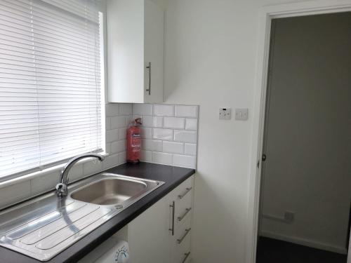 a kitchen counter with a sink and a window at Delight Apartment, Close to Excel, London City Airport & O2! in London